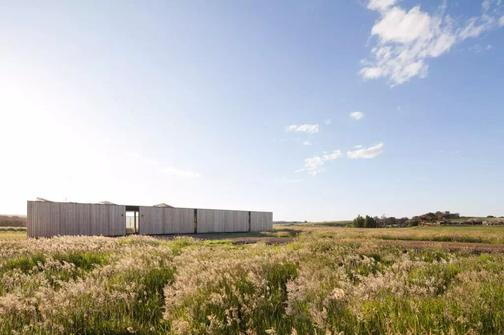 Timber modular home surrounded by a grass field
