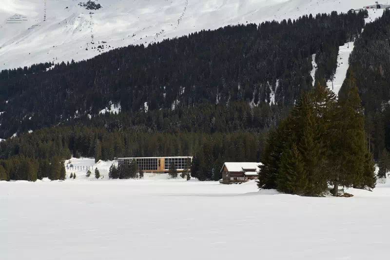 Hotel Revier surrounded by snow and fir trees.