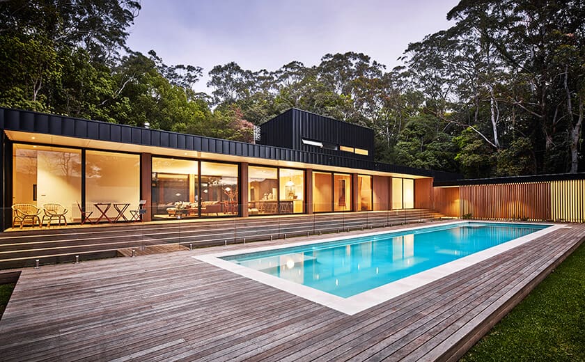 Outside pool infront of luxurious prefabricated home